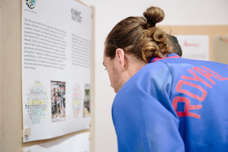 Visitor reads exhibition panels in the Ways of Working exhibition