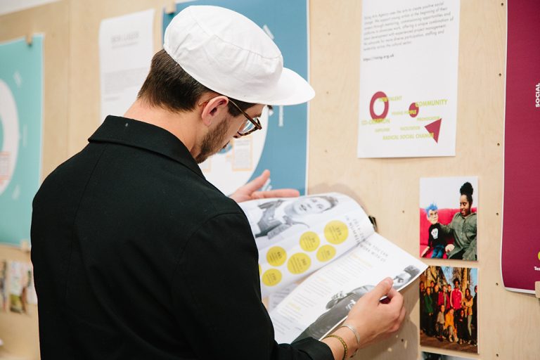 Visitor looks at illustrations produced by one of the entrepreneurs in the Ways of Working exhibition